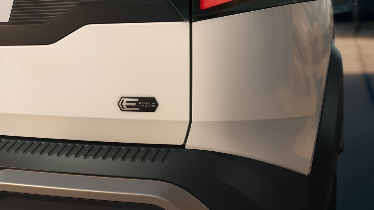 Close view of the E-Tech badge on the rear quarter panel of a white Renault Duster strong hybrid
